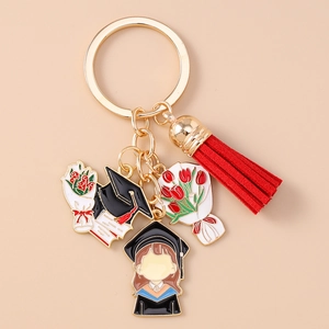 Detailed macro view of Graduation Season metal keychain with red tassel and enamel charms