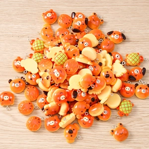 Detailed view of colorful resin animal charms including pigs and frogs with metal rings