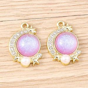 Detailed close-up of crescent moon charms with purple opal finish and faux pearls
