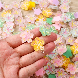 Macro view of assorted resin flower pendants with metal rings for DIY jewelry crafting