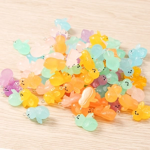 Macro detail of macaron-colored resin bee charms with metal eyelets for DIY jewelry