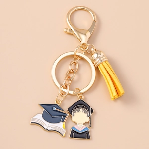 Detailed view of champagne gold graduation keychain with yellow tassel and enamel pendants