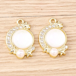 Close-up of crescent moon charms with star engravings, white opal inlay and pearl bead