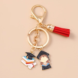 Detail of graduation keychain with golden clasp, red tassel and cartoon graduate charm
