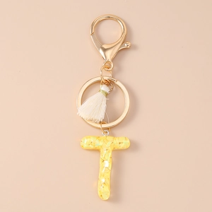 Close-up of letter T sequin keychain with white tassel and gold lobster clasp
