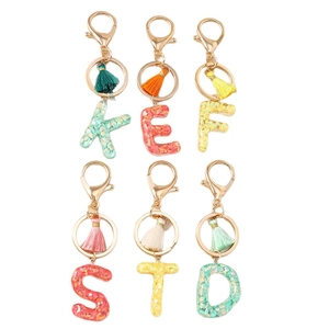 Letter tassel keychain with sparkling sequins and gold-tone lobster clasp on white background