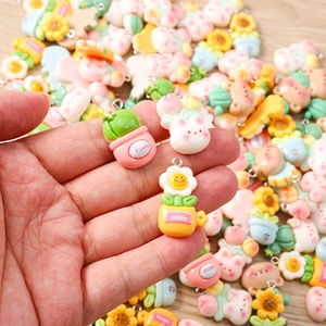 Close-up of mixed resin flower and cactus charms held in hand for DIY jewelry making