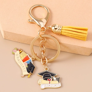 Detail of graduation keychain with golden lobster clasp yellow tassel and graduate charms