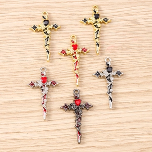 Gothic cross pendants with heart and rose motifs in gold and silver finishes