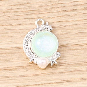 Detailed close-up of crescent moon and star pendant with opal stone and rhinestones