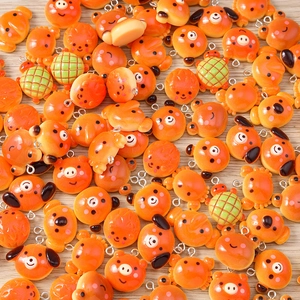Close-up of bright orange resin animal charms like dogs and crabs for DIY jewelry making