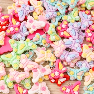 Macro shot of colorful resin butterfly pendants with floral relief and silver metal rings