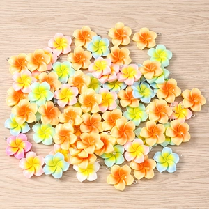 Macro view of colorful resin frangipani flower pendants with metal loops for DIY jewelry