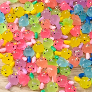 Macro shot of colorful resin bird charms with metal loops for DIY jewelry making