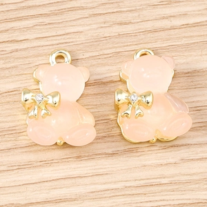 Cinque pezzi di simpatici ciondoli a forma di orso rosa traslucido con fiocco d'oro per gioielli