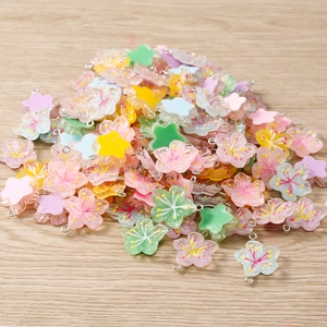 Close-up of assorted resin cherry blossom pendants in pastel colors for jewelry making