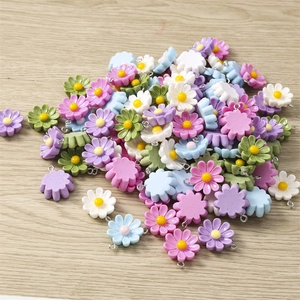 Macro detail of assorted colorful resin daisy charms with metal loops for DIY jewelry making