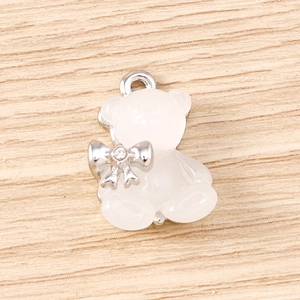 Dettaglio del ciondolo a forma di orsetto traslucido con fiocco d'argento e strass