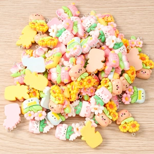 Close-up of assorted resin flower and bear charms with metal loops for DIY jewelry making