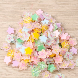 Macro shot of colorful resin flower charms with metal loops for DIY jewelry making