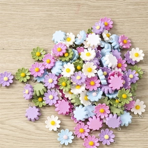 Macro detail of colorful resin daisy charms with metal rings for DIY jewelry crafting