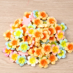 Detailed macro of colorful resin plumeria flower charms with metal loops for DIY jewelry