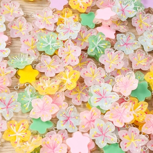 Macro shot of colorful resin cherry blossom flower pendants with silver metal loops