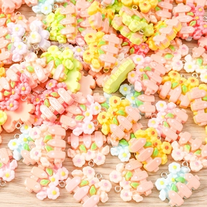 Macro detail of assorted pastel resin flower fence charms with metal loops for DIY jewelry