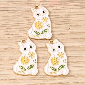Detailed close-up of colorful daisy cat enamel charms on a light wood background