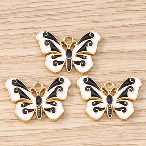 Macro detail of three enamel butterfly pendants with gold plating for DIY jewelry