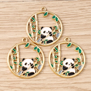 Vue détaillée de breloques émaillées panda et bambou avec bord doré pour bijoux artisanaux