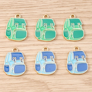 Detalle de dijes de mochila en esmalte de colores para creación de joyería artesanal DIY
