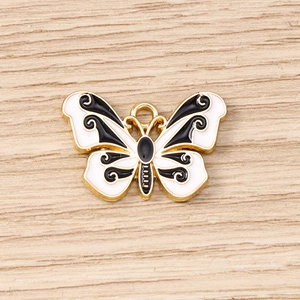 Detailed close-up of butterfly pendant with black and white enamel and golden plating