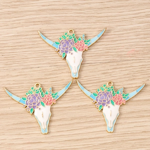 Dettaglio di ciondoli a teschio di mucca stile western con fiori per gioielli fai da te