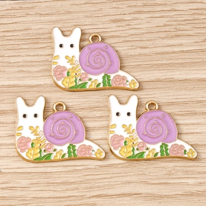 Detailed close-up of cartoon snail enamel charms with purple shells and pink roses