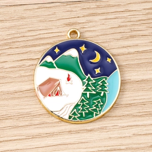 Detailed close-up of a round enamel pendant featuring a colorful camping mountain scene