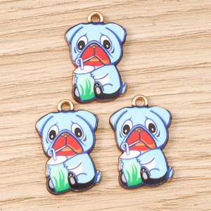 Trois breloques bouledogue en émail bleu buvant du thé sur fond de texture bois clair