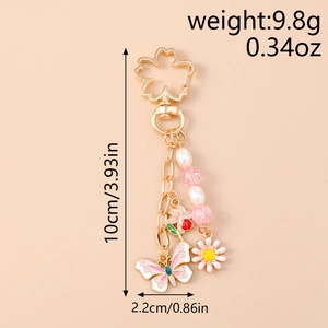 Close-up of floral keychain with pink butterfly charms and size dimensions in inches