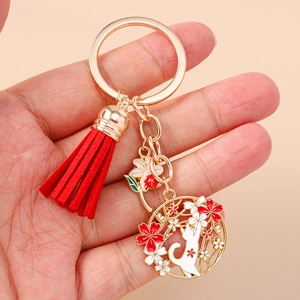 Detail view of Japanese style cat and cherry blossom keychain held in hand