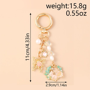 Detailed view of golden butterfly wreath keychain with pearl and star charms size markings