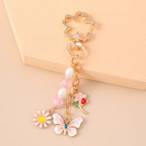 Close-up of pink flower and butterfly charms on a gold-tone floral keychain hook
