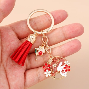 Detailed close-up of a Chinese style keychain with red silk tassel and rabbit charms
