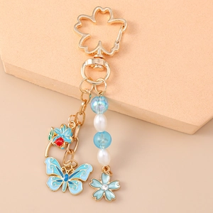 Close-up of cherry blossom key ring with blue butterfly charm and pearl beads
