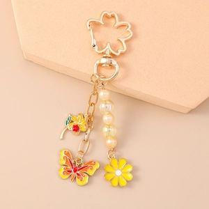 Detail of flower and butterfly keychain with cherry blossom clasp and pearls
