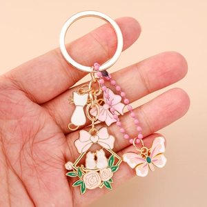 Portachiavi dorato con fiori e coniglio con ciondoli smaltati tenuti a mano su beige