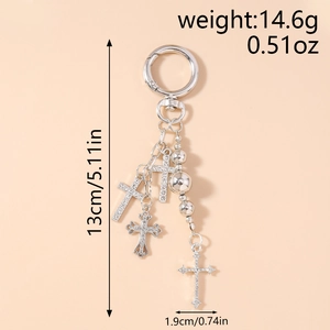Detailed view of silver cross keychain with rhinestones and polished metal beads
