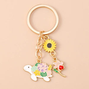 Detail of sunflower and floral turtle keychain charms with golden metal key ring