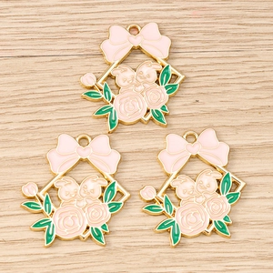Detailed macro view of three enamel rabbit flower wreath pendants for DIY jewelry