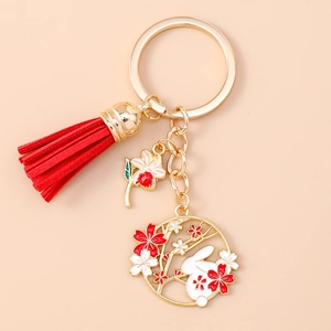 Japanese style keychain with gold ring, red tassel, and cherry blossom rabbit charm