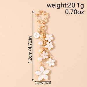 Detailed view of cherry blossom keychain dimensions with white enamel flowers and gold lobster clasp